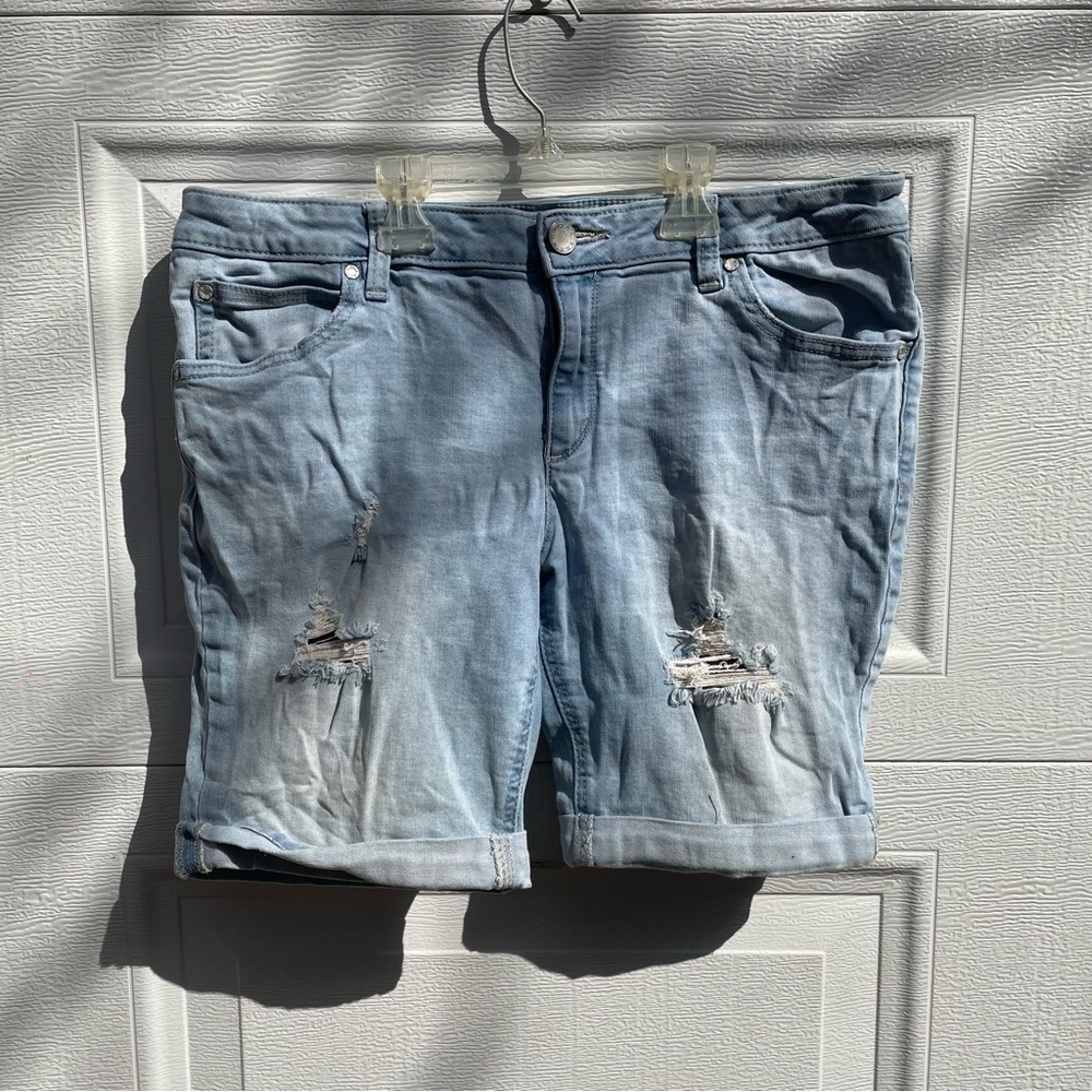 Jean shorts size 10 petite rips on both legs in front. Hem folded. Light blue